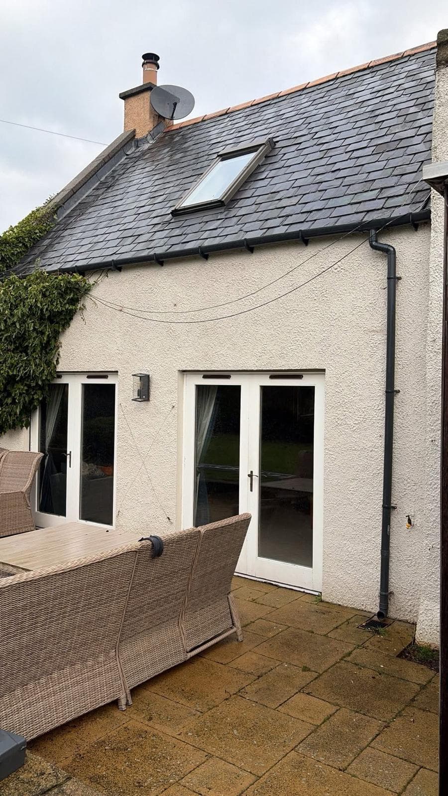 Slate roof with a rooflight, chimney flashing, gutter and downpipe